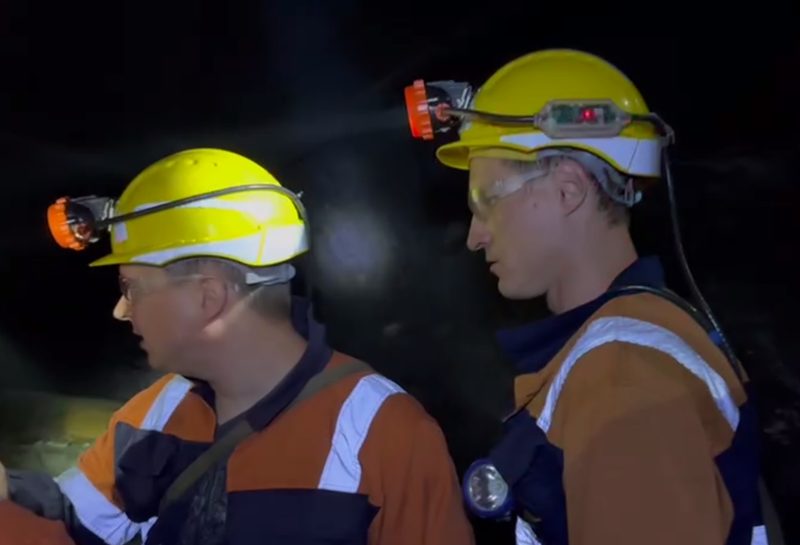 Miners in hard hats with cap lamps in an underground mine working Miners in hard hats with cap lamps in an underground mine working