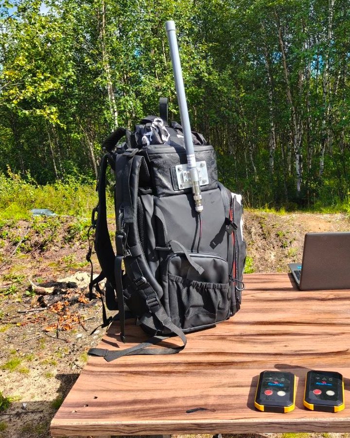 RealTrac mobile kit in an open area: backpack with a communication station and antenna, personal tags